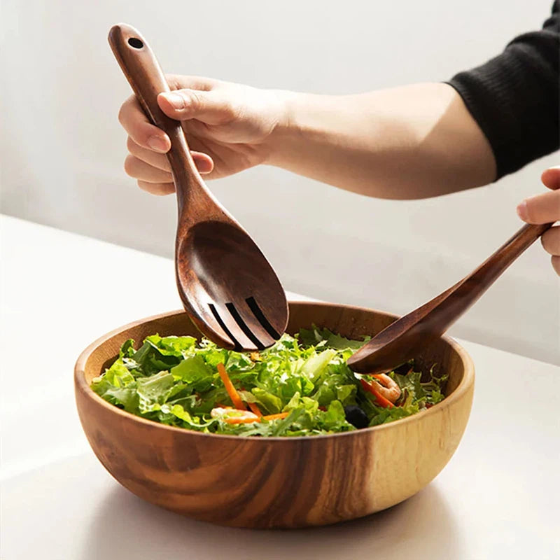 Wooden large spoon and fork set with long handles used for serving salad.