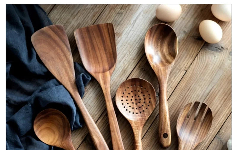 Wooden kitchen utensils set with spatula, spoon, and ladle on wooden surface.